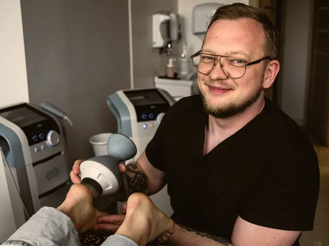 Marcin Jędrzejewski z głowicą fali uderzeniowej skupionej przy stopie pacjenta