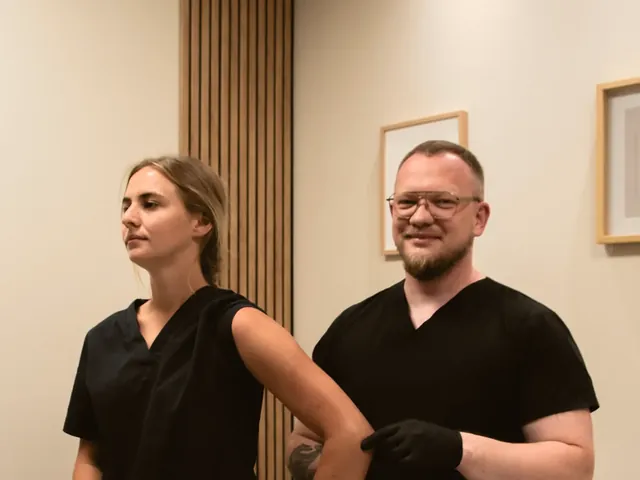 Fizjoterapeuta Marcin Jędrzejewski rozmawia z pacjentką w gabinecie przed badaniem barku